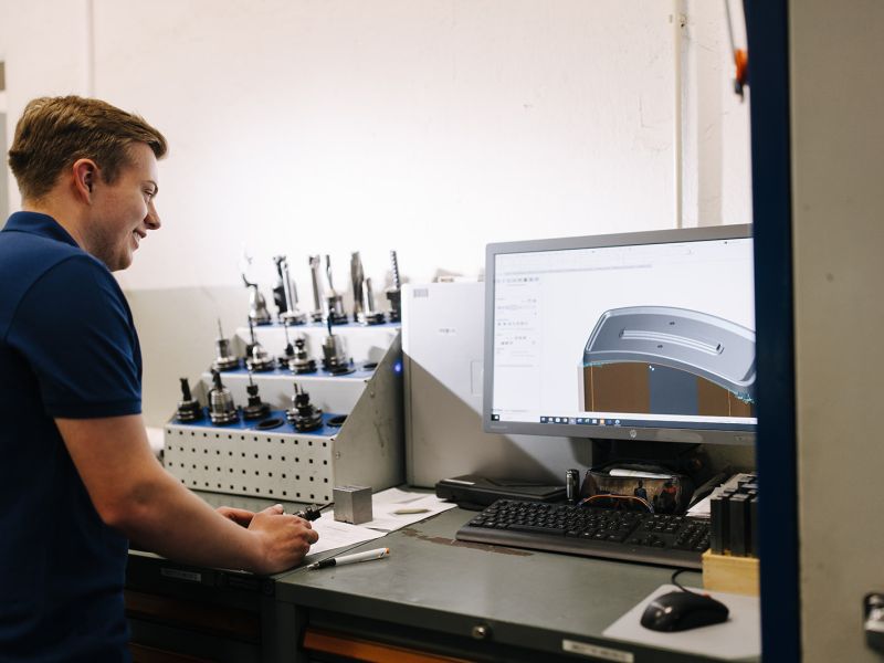 Junger Mitarbeiter prüft 3D-Modell zur CNC-Bearbeitung – digitale Fertigung bei Metalltechnik Börde.